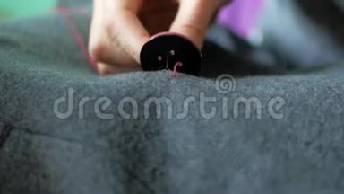 女裁缝在她的衣服上缝一个纽扣。 针线活和小衣服修理